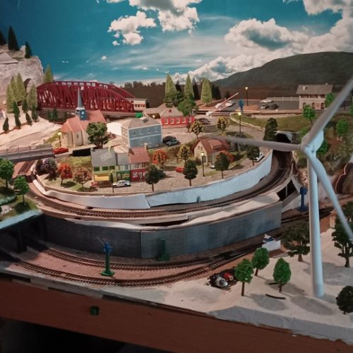 Éolienne avec village au dessus d'une double spirale ferrovoaire